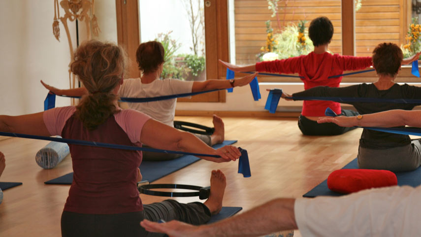 Plusieurs personnes ont participé à une séance de Pilates dans une salle lumineuse, mettant en valeur différentes poses et un sens de la communauté aux Corpus Studios.